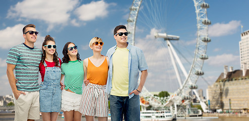 Image showing friends in sunglasses over ferry wheel in london