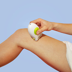 Image showing shaves leg by white epilator