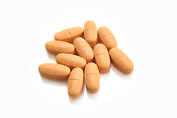 Image showing Heap of orange pills on white background