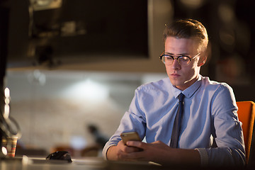 Image showing man using mobile phone in dark office