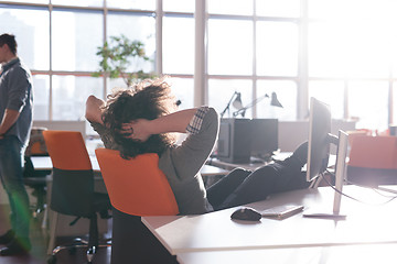 Image showing businessman sitting with legs on desk