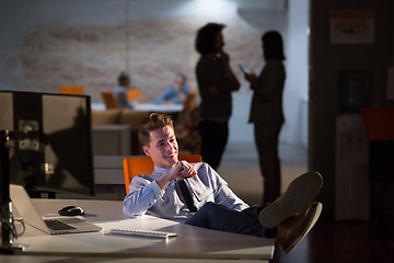 Image showing businessman sitting with legs on desk at office