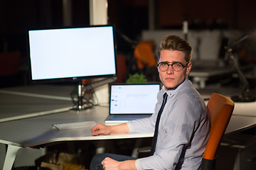 Image showing man working on computer in dark office