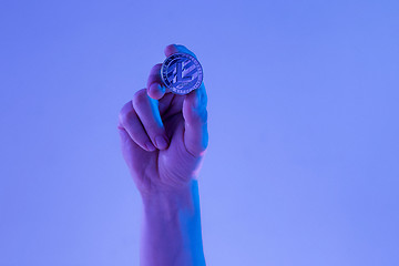 Image showing Male hand with golden Litecoin on blue background