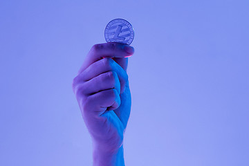 Image showing Male hand with golden Litecoin on blue background