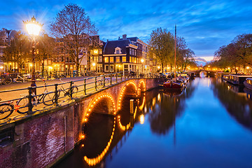 Image showing Amterdam canal, bridge and medieval houses in the evening