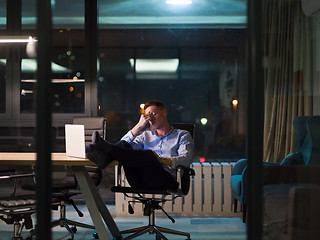 Image showing businessman sitting with legs on desk at office