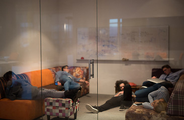 Image showing software developers sleeping on sofa in creative startup office