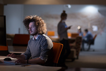 Image showing man working on computer in dark office