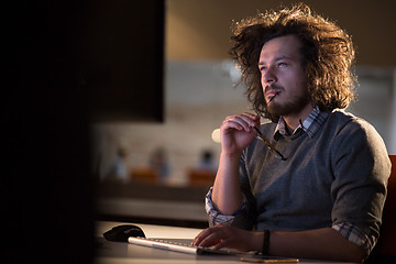 Image showing man working on computer in dark office