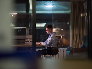 Image showing man working on laptop in dark office