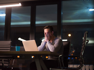 Image showing man working on laptop in dark office