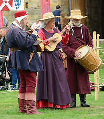 Image showing Three musicians perform at a fair in medieval costume