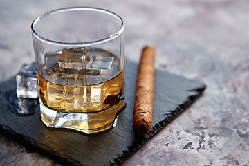 Image showing Glass of whiskey with ice cubes and cigar