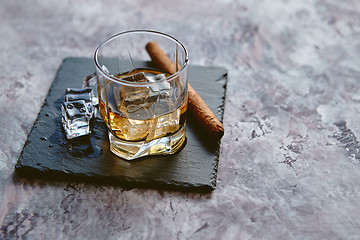 Image showing Glass of whiskey with ice cubes and cigar