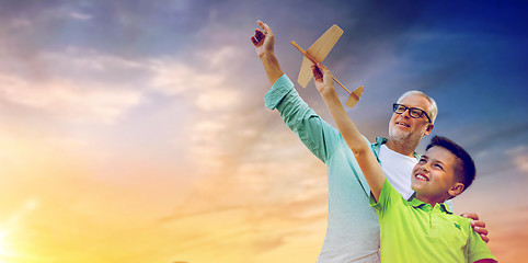 Image showing senior man and boy with toy airplane over sky