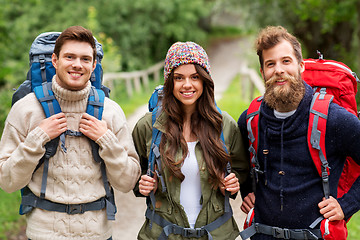 Image showing happy friends or travelers with backpacks hiking