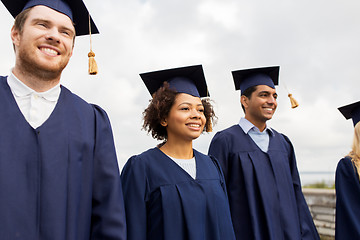 Image showing happy students or bachelors in mortar boards