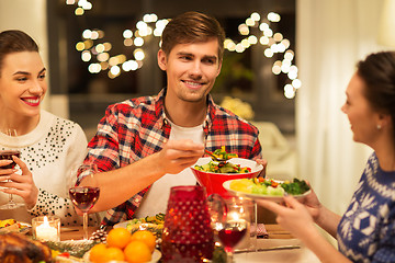 Image showing happy friends having christmas dinner at home