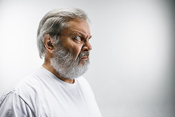 Image showing Senior man with disgusted expression repulsing something on white