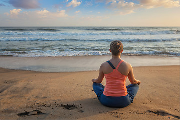 Image showing Woman doing yoga oudoors at beach - Padmasana lotus pose