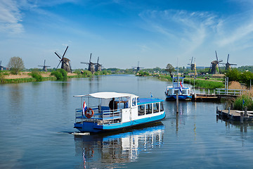 Image showing Netherlands rural lanscape with tourist boat and windmills at famous tourist site Kinderdijk in Holland