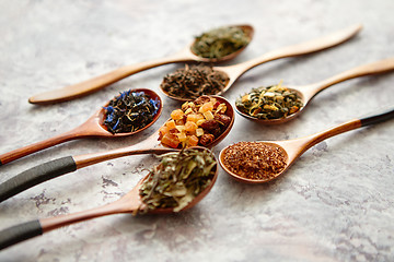 Image showing Virious kinds of tea in wooden spoons on stone table