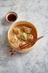 Image showing Delicious chinese dumplings served in wooden bamboo steamer