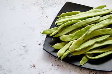 Image showing Black ceramic plate with fresh green bean pods