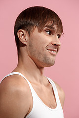 Image showing The happy man standing and smiling against pink background.