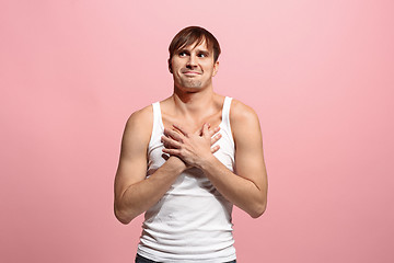 Image showing The happy man standing and smiling against pink background.