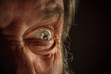 Image showing Half face of aggressive man looking with hatred into camera, domestic tyrant