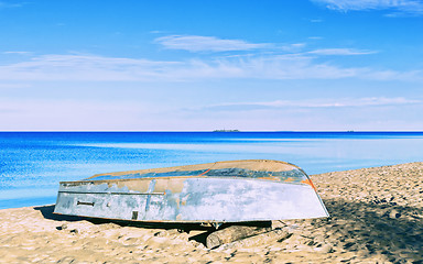 Image showing Boat On A Sandy Shore Under A beautiful Blue Sky