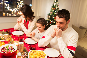 Image showing family praying before meal at christmas dinner