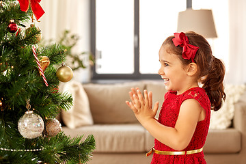 Image showing little girl decorating christmas tree at home