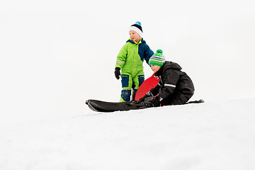 Image showing kids sliding on sleds down snow hill in winter