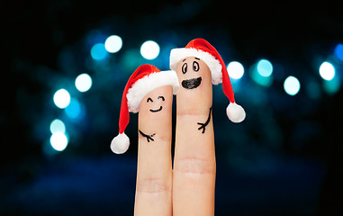 Image showing finger couple in santa hats over lights