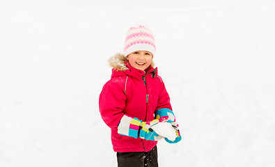 Image showing happy little girl playing with snow in winter
