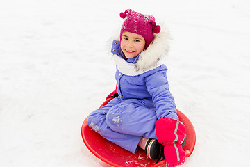 Image showing happy little girl with snow saucer sled in winter