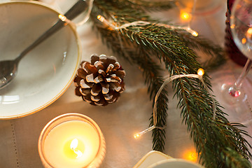 Image showing pine cone and candle burning on christmas table