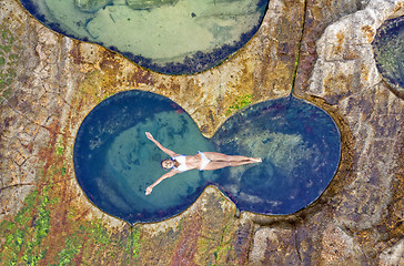 Image showing Female floating in idyllic ocean rock pool just bliss