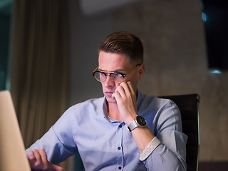 Image showing man working on laptop in dark office