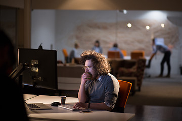 Image showing man working on computer in dark office