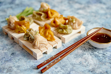 Image showing Delicious mixed kinds of chinese dumplings served on wooden stands