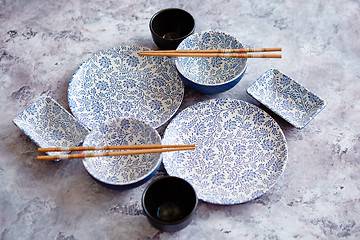 Image showing Empty oriental style dishware set on gray stone background