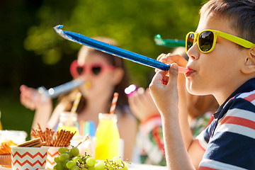 Image showing kids blowing party horns on birthday in summer