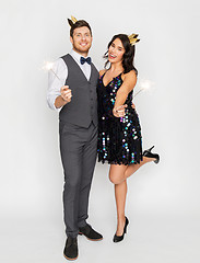 Image showing happy couple with crowns and sparklers at party