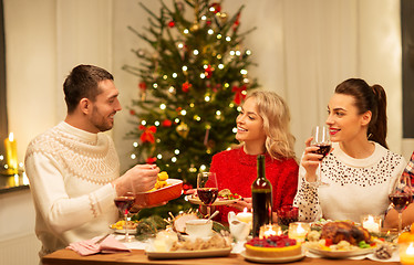 Image showing happy friends having christmas dinner at home