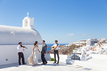 Image showing Bride and groom dansing on wedding ceremony on Santorini island, Greece.