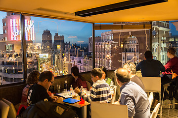 Image showing People enjoying evening drinks and amazing panoramic views of Madrid at dusk on rooftop bar of El Corte Ingles department store in Madrid, Spain.